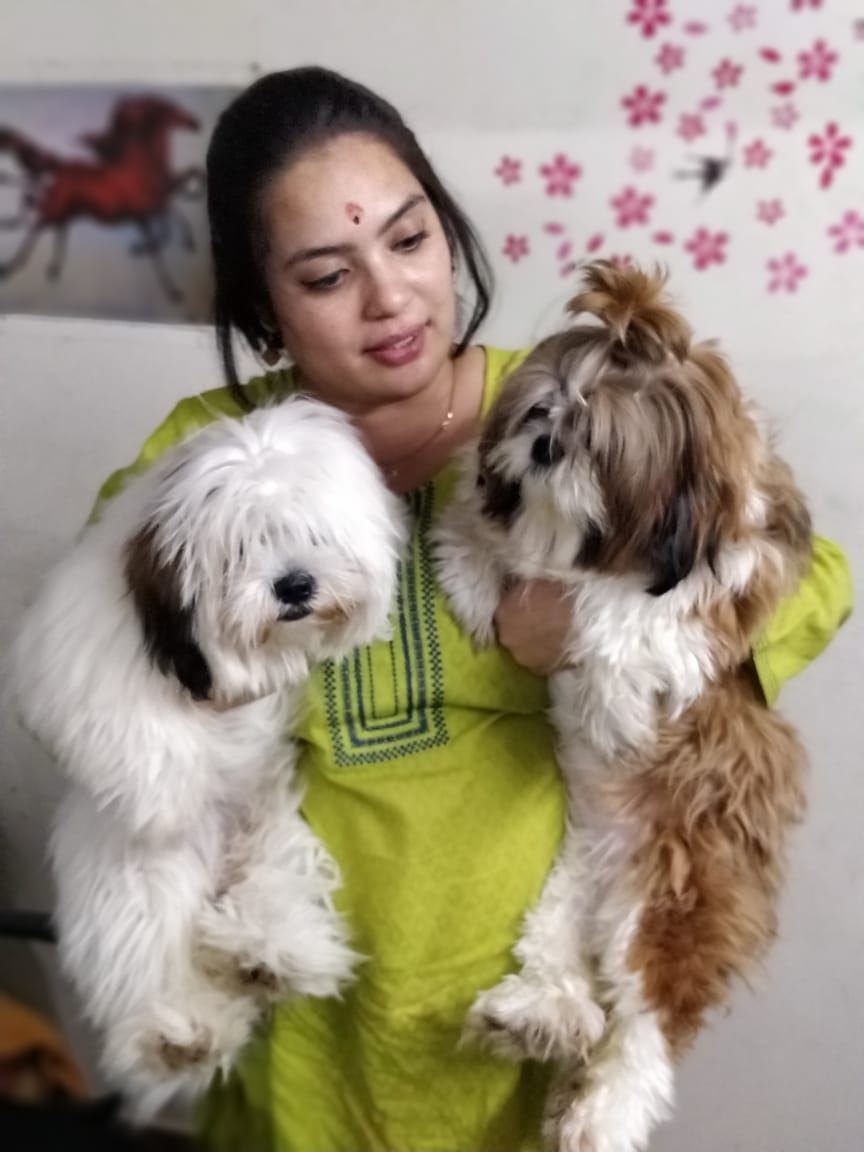 Dr. Pooja Hirulkar holding two rescued dogs