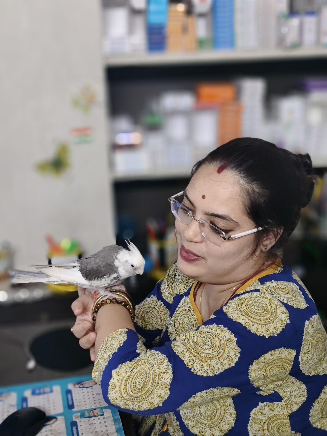 A cockatiel perched on Dr. Pooja Hirulkar's hand