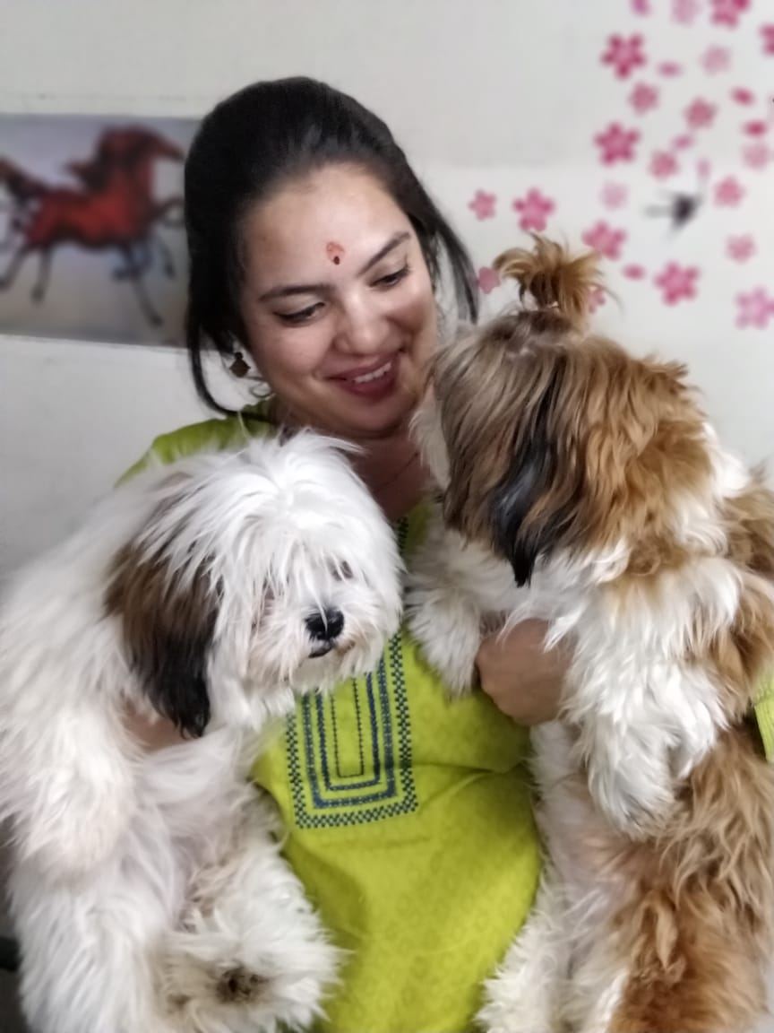 Dr. Pooja Hirulkar holding two rescued dogs at the clinic